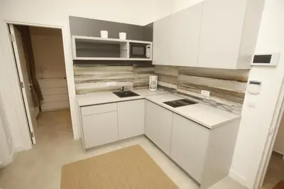 a small kitchen with white cabinets and a microwave at TRAMVAJ Apartments in Belgrade