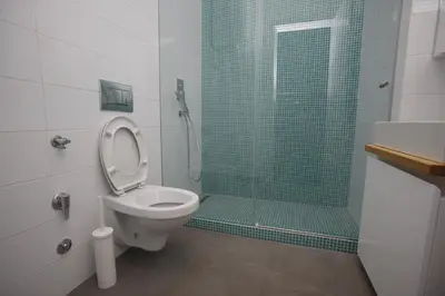 a bathroom with a toilet and a shower with a glass door at TRAMVAJ Apartments in Belgrade