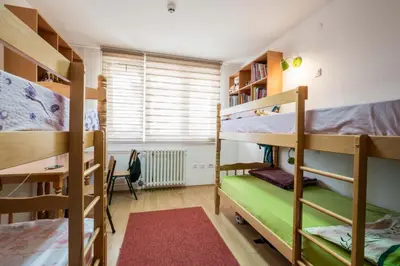 a room with three bunk beds and a desk at Petar Drapšin Hostel in Belgrade