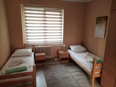 two twin beds in a room with a window at Petar Drapšin Hostel in Belgrade