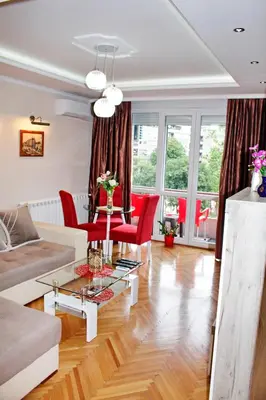 a living room with a couch and red chairs at Kristi Lux Apartment Center Free Parking Fast WiFi in Belgrade