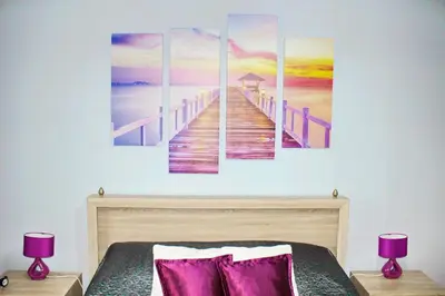 a bedroom with a bed with a painting of a pier at Kristi Lux Apartment Center Free Parking Fast WiFi in Belgrade
