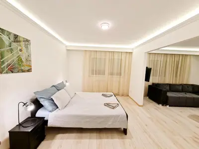 a white bedroom with a bed and a couch at Modern Central Apartments RENOVATED in Belgrade