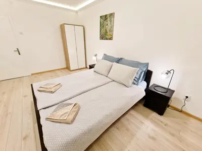 a bedroom with a large bed with two towels on it at Modern Central Apartments RENOVATED in Belgrade