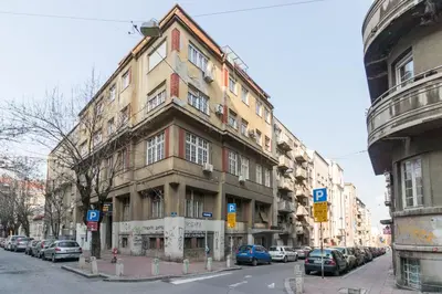 a large building on a city street with cars parked at Modern Central Apartments RENOVATED in Belgrade
