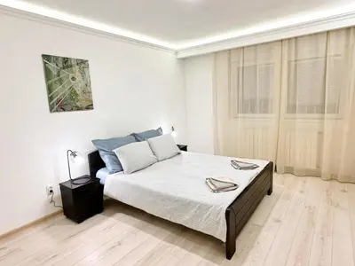 a white bedroom with a bed and a window at Modern Central Apartments RENOVATED in Belgrade