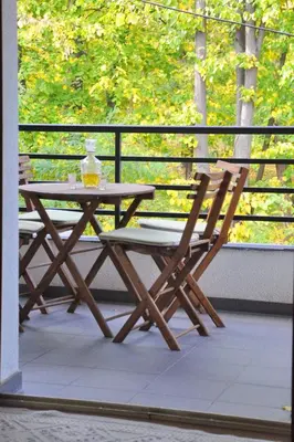 a picnic table and two chairs on a porch at Apartmani15 in Arandjelovac