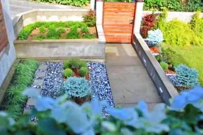 a garden with blue flowers and plants at Apartmani15 in Arandjelovac