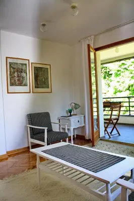a living room with a table and chairs and a patio at Apartmani15 in Arandjelovac