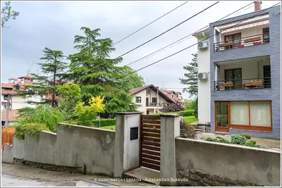 a house with a gate in front of a building at Apartmani15 in Arandjelovac