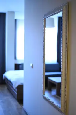 a mirror on a wall in a room with a bed at B&B Villa Panuka in Pančevo