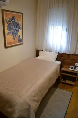 a small bedroom with a bed and a window at B&B Villa Panuka in Pančevo