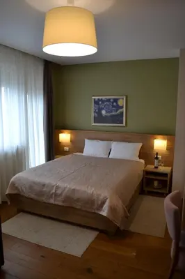 a bedroom with a large bed and a large window at B&B Villa Panuka in Pančevo
