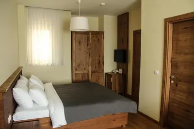 a bedroom with a bed with white pillows and a window at B&B Villa Panuka in Pančevo