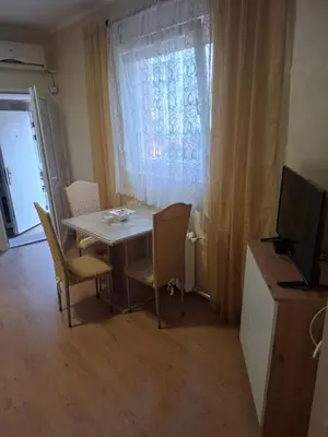 a dining room with a table and chairs and a television at Apartment Sleep'n Drive in Belgrade