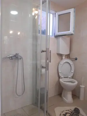 a bathroom with a toilet and a glass shower at Apartment Sleep'n Drive in Belgrade