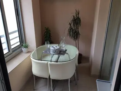 a glass table in a room with chairs and a window at Apartment Gorki in Belgrade