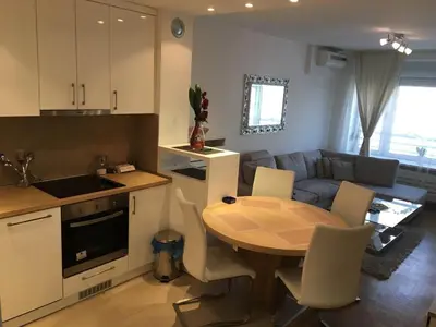 a kitchen and living room with a table and a couch at Apartment Gorki in Belgrade