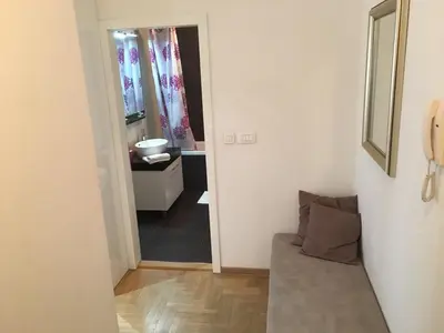 a living room with a couch and a bathroom at Apartment Gorki in Belgrade