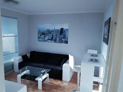 a living room with a black couch and a table at Apartment Arena Silver in Belgrade