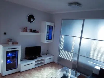 a living room with a flat screen tv on a cabinet at Apartment Arena Silver in Belgrade