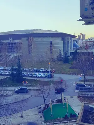a parking lot with cars parked in front of a building at Apartment Arena Silver in Belgrade