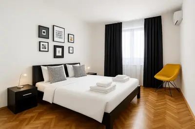 a bedroom with a white bed and a yellow chair at Apartment Wake Up For 4 in Belgrade