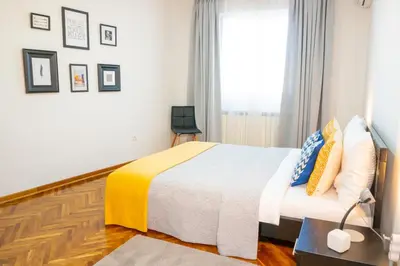 a bedroom with a bed with a yellow and blue blanket at Apartment Wake Up For 4 in Belgrade