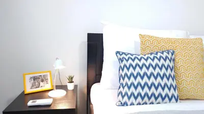 a bedroom with a bed with a pillow and a table at Apartment Wake Up For 4 in Belgrade