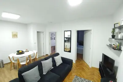 a living room with a black couch and a table at Apartment Wake Up For 4 in Belgrade