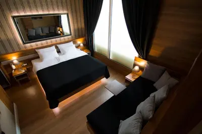 a bedroom with a bed and a mirror and a couch at B&B Wimbledon Garni Concept in Belgrade