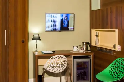 a room with a desk with a chair and a tv at B&B Wimbledon Garni Concept in Belgrade