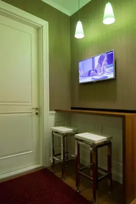 a room with two tables and a tv on the wall at B&B Wimbledon Garni Concept in Belgrade