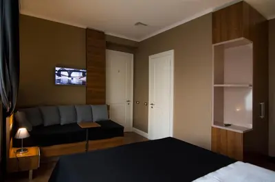 a bedroom with a bed and a couch in it at B&B Wimbledon Garni Concept in Belgrade