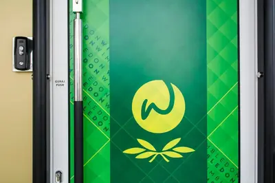 a door with a green and yellow sign on it at B&B Wimbledon Garni Concept in Belgrade