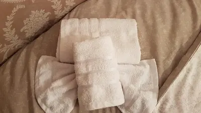 a pair of white towels sitting on top of a bed at Nusha Apartments in Belgrade