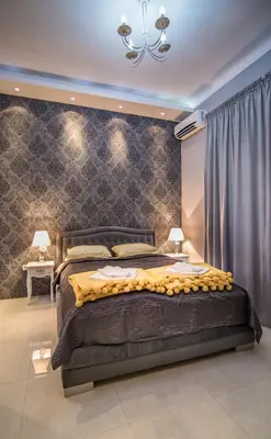 a bedroom with a large bed and a chandelier at Nusha Apartments in Belgrade