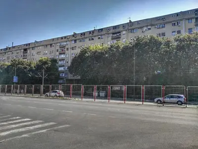 a building with a fence next to a street at Sleep and Go Pedja in Belgrade