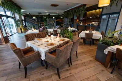 a dining room with white tables and chairs at Hotel Crystal in Pećinci