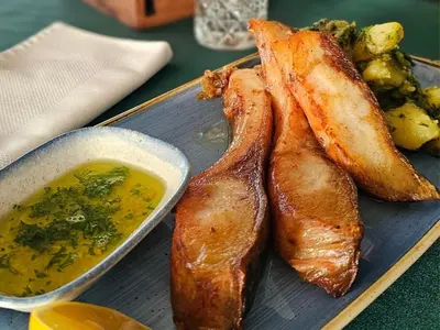 a plate of food with fish and a bowl of soup at Hotel Crystal in Pećinci