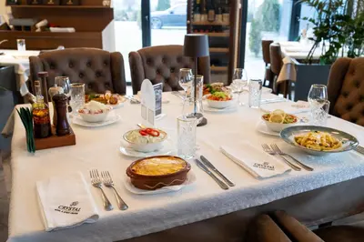 a table with plates of food on it at Hotel Crystal in Pećinci
