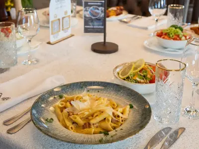 a table with a plate of pasta on it at Hotel Crystal in Pećinci