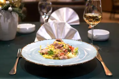 a plate of food on a table with a glass of wine at Hotel Crystal in Pećinci