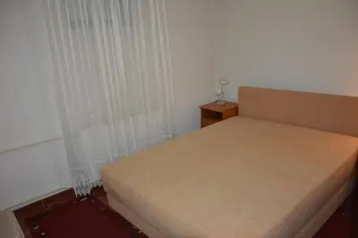 a small bedroom with a bed with a curtain and a window at Villa Stella Smederevo in Smederevo