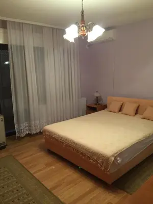 a bedroom with a bed and a chandelier at Villa Stella Smederevo in Smederevo