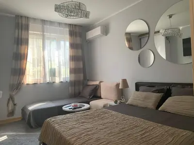 a bedroom with a bed and a couch and a mirror at Apartment Skadarlija FREE parking in Belgrade