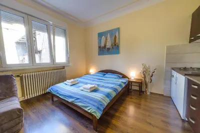 a small bedroom with a bed and a kitchen at Parliament Apartment in Belgrade