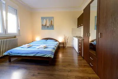 a bedroom with a bed with blue sheets and a window at Parliament Apartment in Belgrade