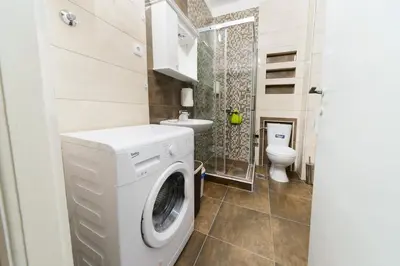 a washing machine in a bathroom with a toilet at Parliament Apartment in Belgrade