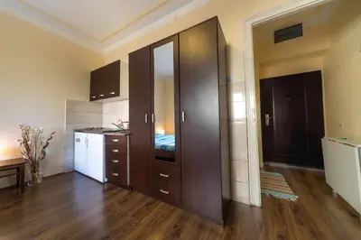 a room with a kitchen with wooden cabinets and a kitchen at Parliament Apartment in Belgrade